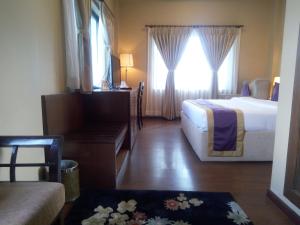 Tempat tidur dalam kamar di Hotel Harmika