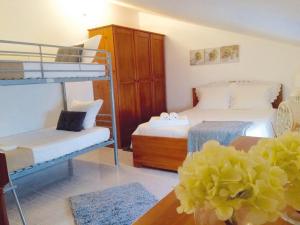 a bedroom with two bunk beds and a table with a flower at Casa BeijoMar in Nazaré