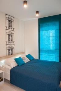 a bedroom with a blue bed and a blue window at Apartament Winogrady Hawelańska in Poznań