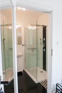 bagno con doccia in vetro e lavandino di Apartament Winogrady Hawelańska a Poznań