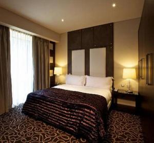 sypialnia z dużym łóżkiem w pokoju hotelowym w obiekcie The Wheatbaker w mieście Lagos