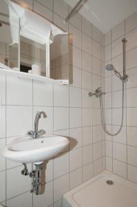a white bathroom with a sink and a shower at Landhotel Alte Mühle in Modautal