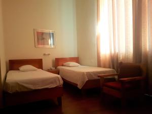 A bed or beds in a room at Lena Hotel