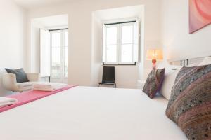 リスボンにあるFLH Principe Real Design Flatの白いベッドルーム(大型ベッド1台、窓2つ付)