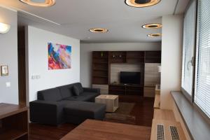 Una sala de estar con un sofá y un televisor. en 22nd Uprising Square, en Bratislava