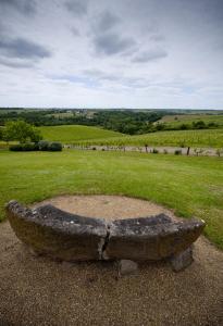 una panchina di pietra seduta in cima a un campo di Domaine de la Soucherie - Chambres d'hôtes a Beaulieu-sur-Layon