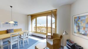 un salon avec une table et des chaises et une fenêtre dans l'établissement Splerin C5, à Silvaplana