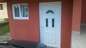 een witte deur en een raam op een huis bij Apartments Popovic in Podgorica