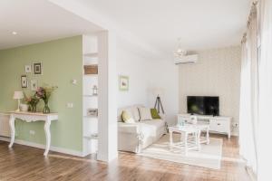 uma sala de estar com um sofá branco e uma televisão em El Horno de los Bizcochos em Toledo