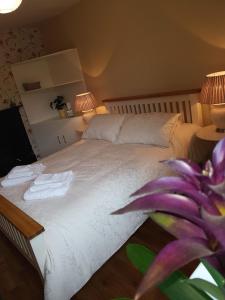 a bedroom with a white bed with towels on it at Glenbower House in Cork