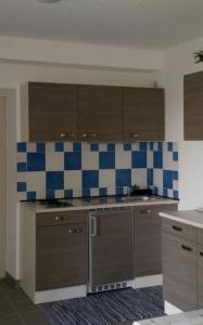 a kitchen with blue and white tiles on the wall at Ferienwohnung "Bäderdreieck" in Haarbach