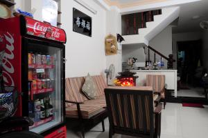 a room with a soda refrigerator and a table with chairs at Diep Anh Guest House in Ho Chi Minh City