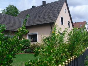 a house with a black roof and a fence at Ferienwohnung Schäffer in Regensburg