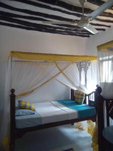 1 dormitorio con 1 cama con mosquitera en Kiponda B&B, en Zanzíbar