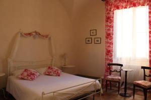 1 dormitorio con 1 cama, 2 sillas y ventana en B&B Antica Biblioteca, en Fermo