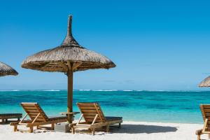 圖德歐多斯的住宿－快樂週五酒店，海滩上的一组椅子和遮阳伞