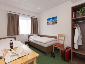 a hotel room with a bed and a desk with a book at Win Budget B&B in Wiener Neustadt