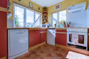 a kitchen with red and white appliances and windows at Ty Pren Bach in Maenclochog