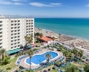 
a beach scene with a large swimming pool at Sol Timor Apartamentos in Torremolinos
