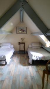 a attic room with two beds and a table at maison kerivarch G in Saint-Pol-de-Léon