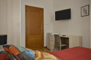 a bedroom with a bed and a desk and a door at Liberty Guest House in Alghero +20 photos