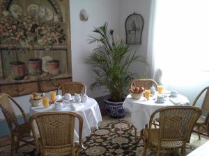 uma sala de jantar com duas mesas e cadeiras e uma planta em La Thebaide em Saint-Trivier-de-Courtes