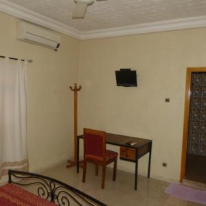 a room with a desk and a chair and a tv at La Venise Malienne in Bamako