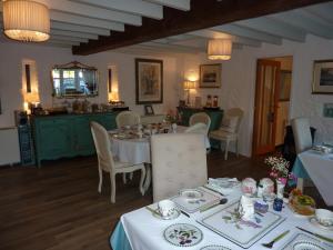 a dining room with a table and chairs and a kitchen at Yr Hen Felin - The Old Mill B&B in Morfa Nefyn