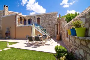 un patio con mesa y sillas frente a una casa en Blue Paradise, en Margarítai