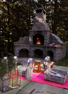 a picnic table with a stone oven in the yard at Green Village Ruševec in Hočko Pohorje