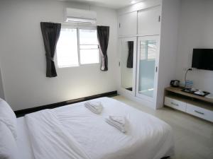 a bedroom with a white bed and a window at Room58 in Bangkok