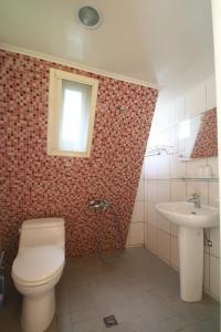 a bathroom with a toilet and a sink at Yulan Green Roof in Datong