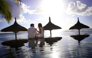 una pareja de pie en el agua en una playa en Recif Attitude (Adults Only) en Pointe aux Piments