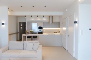 a living room with a white couch and a kitchen at Fani Luxury Apartments Stavros in Stavros
