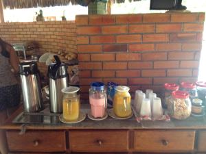 a counter with jars of food and drinks on it at CostaSol Pipa Chalés in Pipa