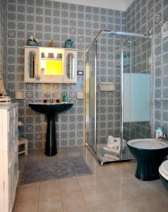 a bathroom with a shower and a sink and a tub at Villa Rosina in Noto