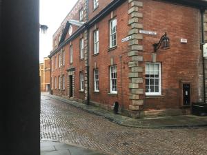 um antigo edifício de tijolos numa rua de calçada em Old County Court em Coventry