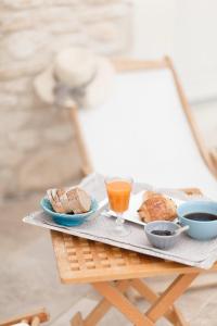 a tray with bread and a glass of orange juice at Provence Dodo in Villeneuve