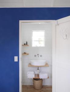 baño con lavabo y ventana en InAweStays Holiday Homes, en Ciudad del Cabo