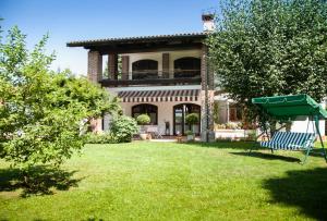 una casa con un patio verde con un columpio en Le Peonie en Peveragno