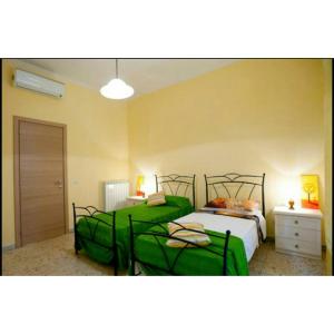 ローマにあるDomus Ines Roma San pietroのベッド2台(緑のシーツ付)が備わるベッドルーム1室