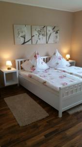 ヴィルヘルムスハーフェンにあるFerienwohnung Daisy 262のベッドルーム1室(花が咲く白いベッド1台付)