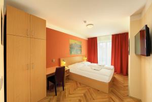 sypialnia z łóżkiem, biurkiem i telewizorem w obiekcie Residence BENE w Pradze