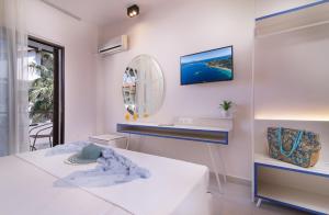 a white room with a bed and a mirror at Sun Rise Hotel in Ammouliani