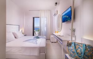 a bedroom with a bed and a desk with a view of the ocean at Sun Rise Hotel in Ammouliani