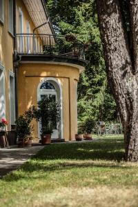 a building with a balcony and a yard with plants at Waldsee Hotel am Wirchensee in Treppeln