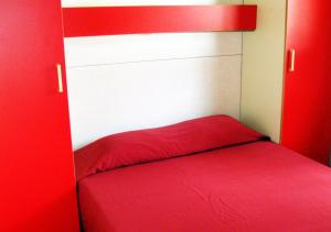 una stanza rossa con un letto con una coperta rossa di Parque de Campismo Orbitur Valverde a Luz Altre 26 foto