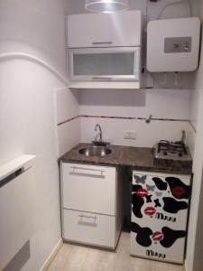a small kitchen with a sink and a stove at Oroño 1 in Rosario