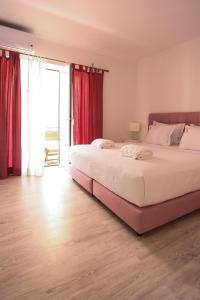 1 dormitorio con 1 cama grande y cortinas rojas en Suites Apartments, en Cascais