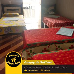 two beds in a room with red covers and a yellow sign at Pousada Pouso Feliz in Fortaleza +11 photos